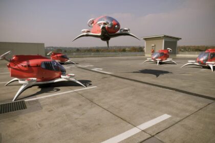 five identical red and white flying taxis in a parking bay