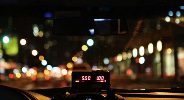 view from inside a taxi cab with fitted meter at night
